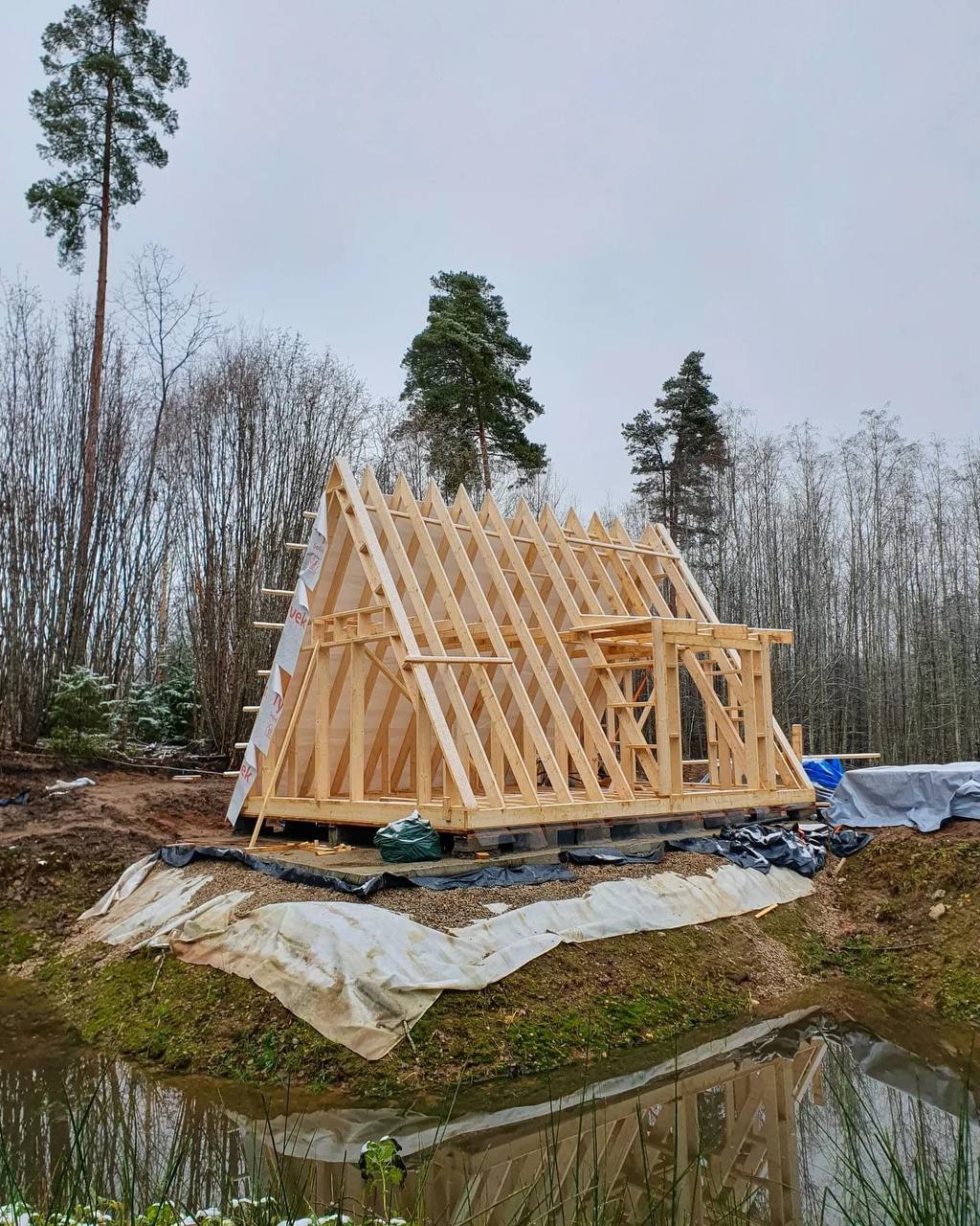 The meme is a photo of a small, unfinished wooden house, often referred to as a "tiny house" or "micro cabin." The image is captioned "When you finally get to build your own tiny house, but you still can't get away from your parents' basement."